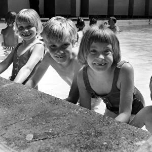 The three surviving Thorns sextuplets with their younger brother David at the swimming