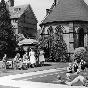 Swimmers laze in the sun by the outdoor pool at Rubery Hill Hospital, Birmingham