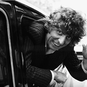 Tom Baker British actor waving from moving taxi cab in November 1980