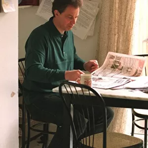 Tony Blair leader of the Labour Party at home in kitchen reading the newspapers after his