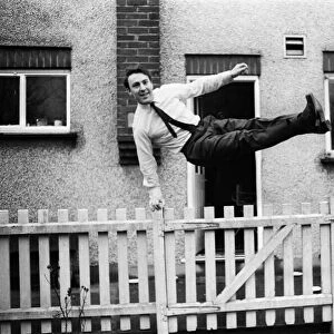 Tottenham Hostpurs footballer Jimmy Greaves leaps over a garden fence, January 1964