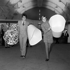 Twiggy with her manager, Justin de Villeneuve carrying some of the paper chairs at