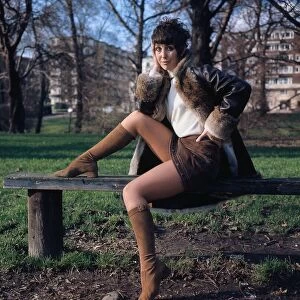 Una Stubbs actress sitting on a bench hand at face