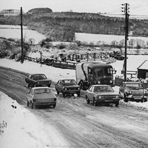 A winter snow scene, 28th March 1977. Cars struggle up a bank at Birches Nook