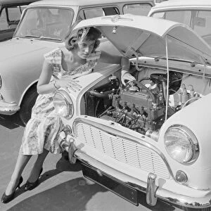 A woman checks the engine of one of the first mini cars designed by Alec Issigonis which