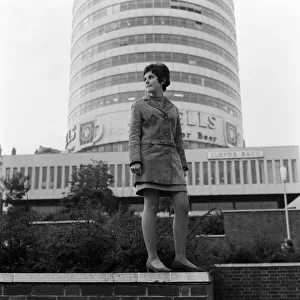 A woman standing in front of the Rotunda in Birmingham, West Midlands. 4th October 1967