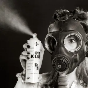 A woman wearing a protective gas mask - February 1981 holding