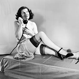 Woman wearing stockings seen here on the telephone. 1959