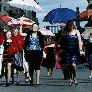 Women dressed as 1920s flapper girls walking down a street during the Edinburgh