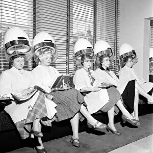 Women at the hairdressers seen here under the driers, April 1956