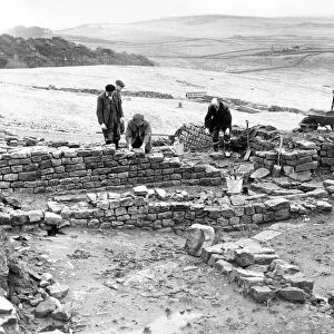 Workmen repair and tidy the remains of the Roman fort at Housesteads in Northumberland in