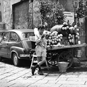 A young boy of Naples in Southern Italy selling goods on the side of the road