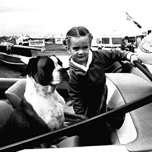 A young girl and her dog try out a speedboat at the Whitley Bay Motor Show. 18 / 07 / 80