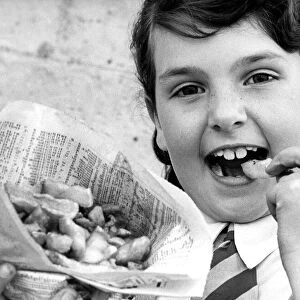 A young girl enjoying fish and chips the old fashioned way from a newspaper in 1977