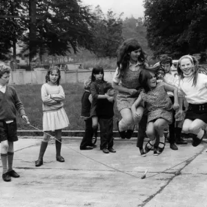 Young girl jumping over a skipping rope in the playground of the National School at