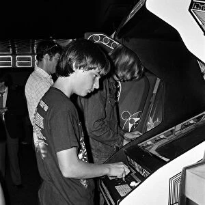 Young people playing video games in an amusement arcade in London. 13th July 1983