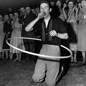A youth yawns as her competes in a Hula Hoop marathon. October 1958 P012316