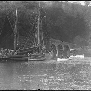 Masted boat being piloted in to Looe Harbour