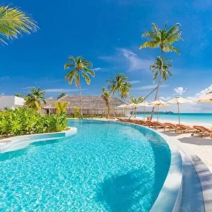 Beach landscape. Luxurious beach resort with swimming pool and beach chairs or loungers under umbrellas with palm trees, vacation, travel holiday