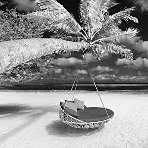 Black and white tropical beach panorama as summer landscape with beach swing or hammock and white sand and dark sea for beach banner. Luxury beach