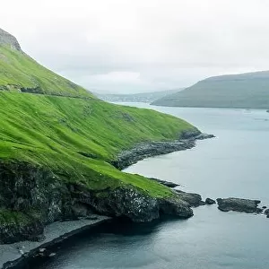 Dramatic view of green hills of Vagar island and Sorvagur town