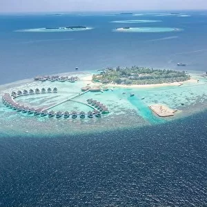 Perfect aerial landscape, luxury tropical resort or hotel with water villas and beautiful beach scenery. Amazing bird eyes view in Maldives, landscape