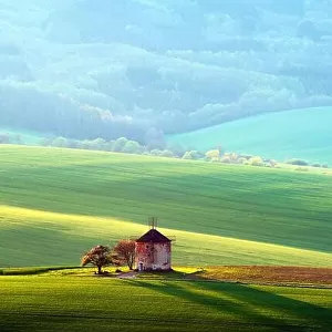 Picturesque rural landscape with old windmill and green sunny spring hills. South Moravia region, Czech Republic