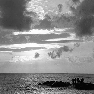 View of the sea with a group of fishermen intent on fishing on the reef