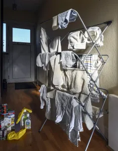 Prints of A hallway of a house, showing nappies and baby clothes on a drying rack, next to cleaning equipment House And Home Prints: Drying Laundry Print DP264628
