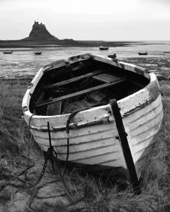 Explore England - Iconic Landmarks and Places to Visit: Lindisfarne Castle Print: Decaying Fishing Boat with Castle