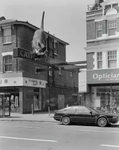 Prints of The Catford Cat a giant fibreglass sculpture at the entrance to the Catford Centre, located between 154 and 158 Rushey Green, Catford, London. Photographed by Paul Barkshire, 12th June 1994 Related Prints: Catford Cat Print, a fibreglass sculpture of a cat