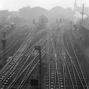 Prints of KINGS CROSS, London. An elevated viewpoint of the railway track to the north of Kings Cross Station, a steam engine on the tracks to either side and St Pancras Station in the far distance. John Gay Iconic Photographers of England - Historic Image Collections: Print of Railway Tracks at Kings Cross, London