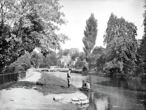 Print of Bourton-on-the-Water, featuring a small boat on the River Windrush
