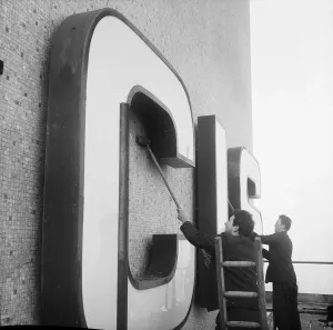 Prints of CIS BUILDING, COOPERATIVE INSURANCE SOCIETY TOWER, MILLER STREET, MANCHESTER. Two Laing workers brushing mosaic tiling around CIS lettering on the service tower Engineering And Construction Prints: Print of CIS Building, Manchester
