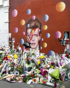 Prints of Flowers and tributes surround the mural of musician David Bowie, January 2016. The mural was painted by Australian street artist James Cochran (aka JimmyC) in 2013 Related Prints: David Bowie Mural Print