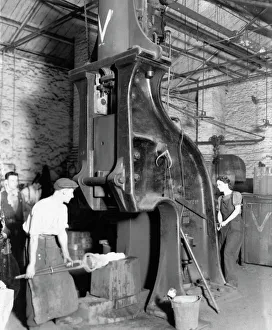 A man and woman carrying out work on a steam hammer during WW2, 1942 A man and woman carrying out work on a steam hammer during WW2, 1942