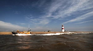 Aldeburgh mersey class lifeboat Freddie Cooper 12-34 moving from right to left, lighthouse in the background Aldeburgh mersey class lifeboat Freddie Cooper 12-34 moving from right to left, lighthouse in the background