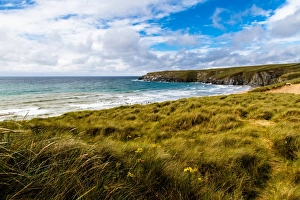 Landscape shot of Holywell beach, Cornwall. People in the sea swimming and surfing Landscape shot of Holywell beach, Cornwall. People in the sea swimming and surfing