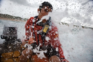 Lifeguard at the helm of an arancia inshore rescue boat at Constantine Bay, Cornwall Lifeguard at the helm of an arancia inshore rescue boat at Constantine Bay, Cornwall