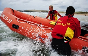 Two lifeguards launching an arancia inshore rescue boat at Constantine Bay, Cornwall Two lifeguards launching an arancia inshore rescue boat at Constantine Bay, Cornwall