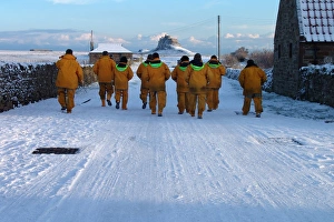 Seahouses crewmembers walk back to their lifeboat in the snow Seahouses crewmembers walk back to their lifeboat in the snow