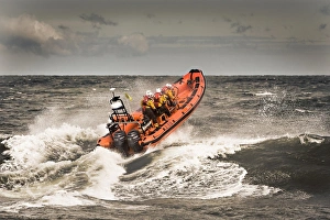 Sheringham Atlantic 85 inshore lifeboat The oddfellows B-818. Lifeboat is heading away from the camera over a breaking Sheringham Atlantic 85 inshore lifeboat The oddfellows B-818. Lifeboat is heading away from the camera over a breaking