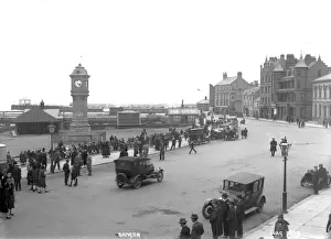 Prints of Bangor - an elevated view of the McKee clock and Quay street, there are people sitting and walking and motor cars parked.. (Location: Northern Ireland; County Down; Bangor). Date: circa early 1900s Bangor Prints: Early 20th Century Print of Bangor, Northern Ireland