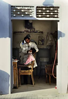 A barber shaves a customer in barbershop in Djerba, Tunisia A barber shaves a customer in barbershop in Djerba, Tunisia