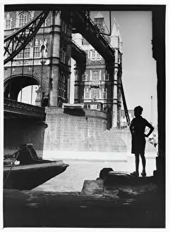 Prints of A boy stands in the shadow of Tower Bridge, London, to admire it Tower Bridge Prints: Tower Bridge Print: A Boy's Admiration