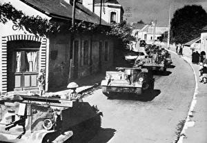 British machine gun carriers passing through French village British machine gun carriers passing through French village