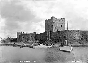 Prints of Carrickfergus Castle - with a boat in the foreground and people visible on the slipway.. (Location: Northern Ireland: County Antrim: Carrickfergus). Date: circa early 1900s Castle Prints: Carrickfergus Castle Print - Early 1900s, Northern Ireland