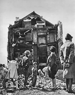 Prints of Gazing at the ruins of their home, which collapsed soon after they fled - tenants of a house in Stepney. The house was typical of much of old housing in London Slums Prints: Collapsed House in Swedenborg Square, Stepney - 1961 Print