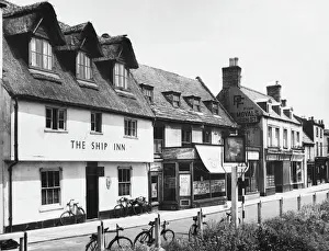 Prints of The market town of March, in the Cambridgeshire Fens, England, showing a deserted street, apart from seven bicycles curiously parked outside the Ship Inn Cambridgeshire Prints: Abandoned Street Scene Print of March, England 1940s