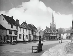 Prints of High Street, Thaxted, Essex, with the fine spire of its Cathedral of Essex church, rising high above the ancient timbered Moot Hall Related Prints: Print of Thaxted High Street with the Cathedral Church spire